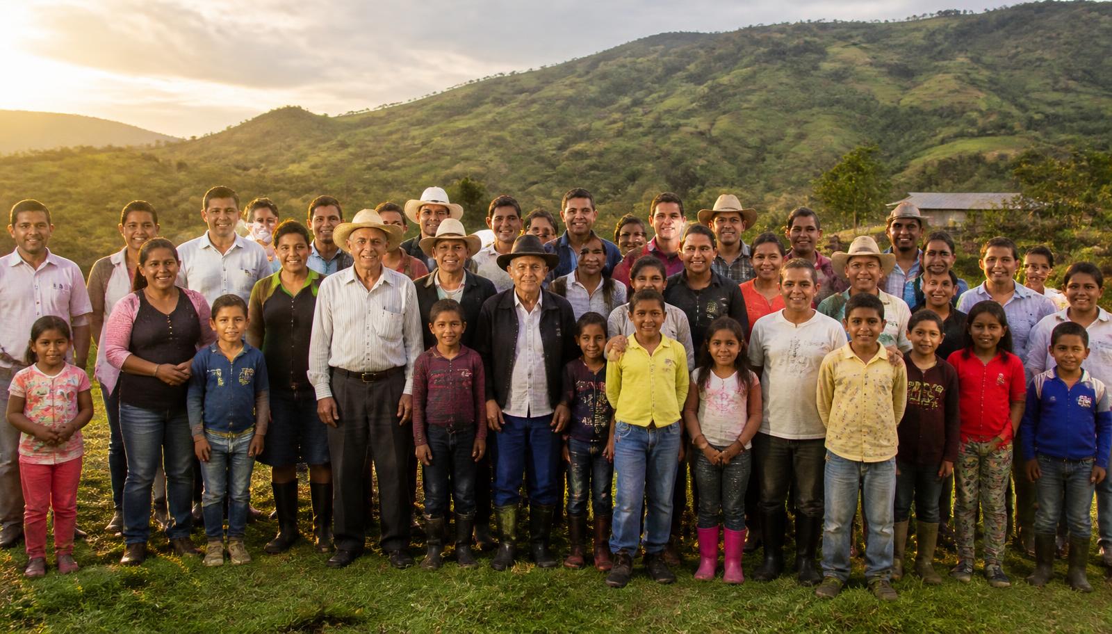 Familias campesinas reunidas en una ladera al atardecer